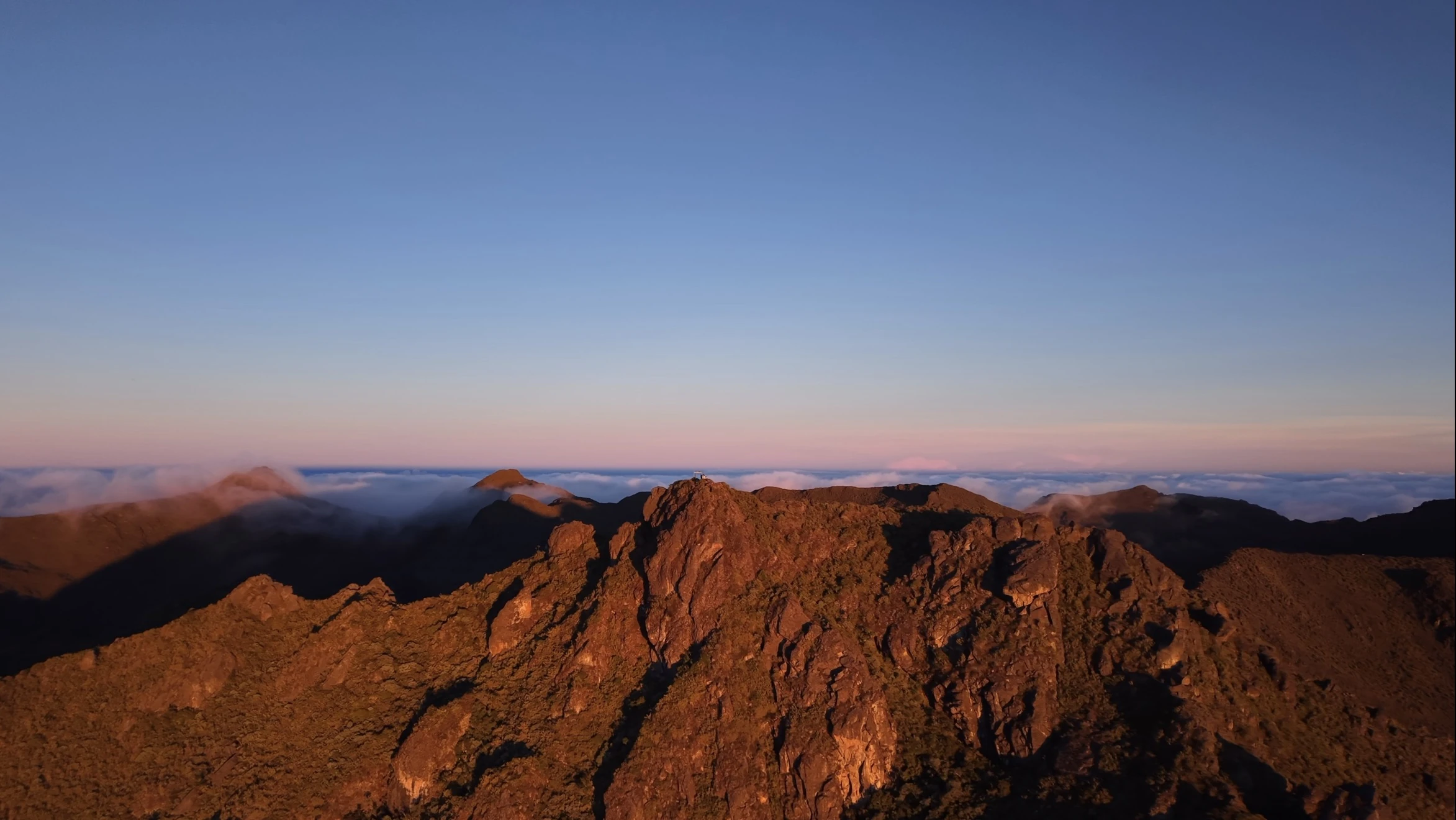 Amanecer sobre las nubes desde una cumbre de monta&ntilde;a